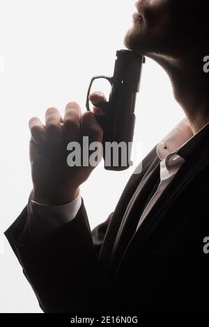 partial view of armed man in suit holding gun isolated on white Stock Photo