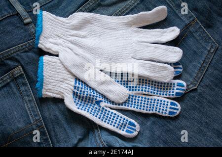 Work gloves white on a denim background Stock Photo