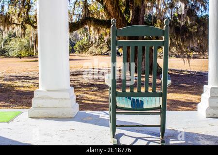 Single empty rocking chair on the front porch of an antebellum style house in the southern United States. Stock Photo