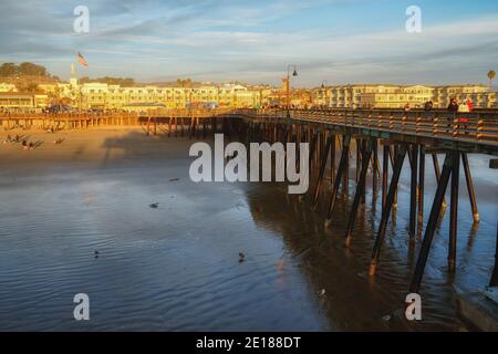 Pismo Beach, California, USA - January 1, 2021 An iconic Pismo Beach pier at sunset. People are enjoying a nice walk and amazing ocean view Stock Photo