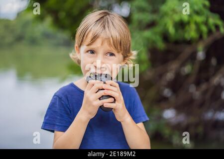 Boy eating Vietnamese Pork Banh Mi Sandwich in a black baguette Stock Photo