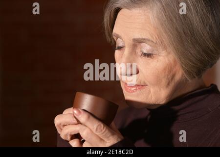 Portrait of beautiful smiling senior woman drinking tea Stock Photo