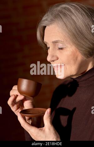 Portrait of beautiful smiling senior woman drinking tea Stock Photo