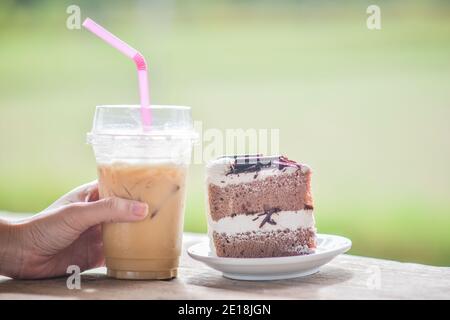 People drink ice coffee in cafe with coconut cake,Ice coffee on wood table Stock Photo