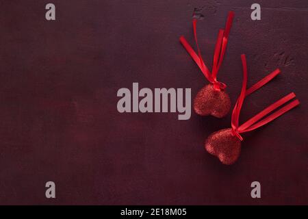 Two hearts on the wooden board painted in dark-red with copy space for text. Flat lay.  Valentine's day background. Stock Photo