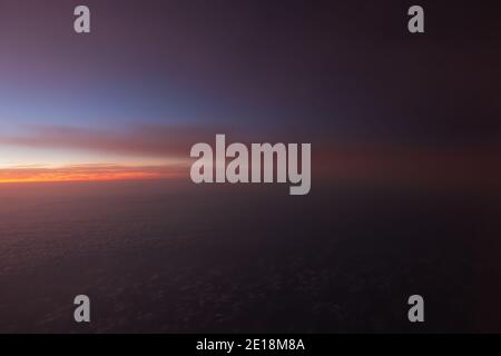 Colorful hues of a dramatic sunrise captured from a flight. Stock Photo