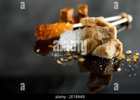 different types of sugar - brown, white and refined sugar on black Stock Photo