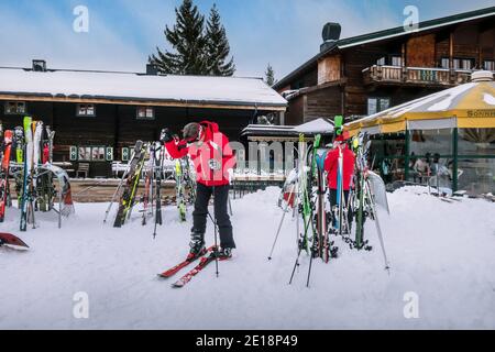 Saalbach, Austria - March 3, 2020: People preparing for skiing near ski slope restaurant Stock Photo