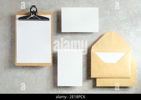 Wedding stationery set on stone table top view. Flat lay blank paper cards, clipboard, envelopes. Stock Photo