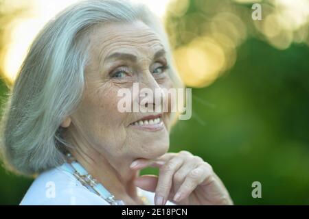 Beautiful smiling senior woman in winter hat and glasses talking on the ...
