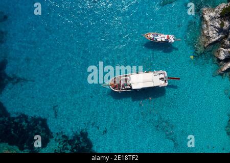 An aerial shot of a daily boat trip with families enjoying their holidays in Greece.