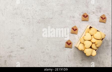 Homemade heart shaped cookies in a box. Valentines Day greeting card with holiday decorations. Flat lay, copy space Stock Photo