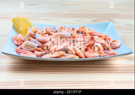 fresh seafood shrimp in white plate. fresh shrimps served on plate. boiled shrimp unpeeled prawns cooked in the seafood restaurant Stock Photo