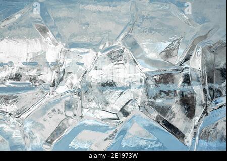 Ice Background. Full frame of the textures formed of a block of cracked ice, on a light blue background. Beautiful natural background. blue frozen tex Stock Photo