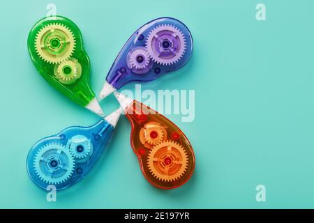 Stationery correction tapes are Multicolored on a blue background. Free space. The view from the top. Blue, green, yellow, lilac Stock Photo