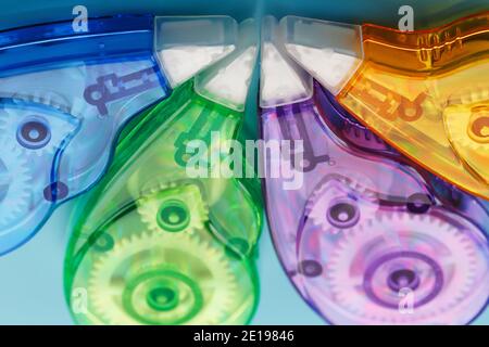 Stationery correction tapes are Multicolored on a blue background. Free space. The view from the top. Blue, green, yellow, lilac Stock Photo