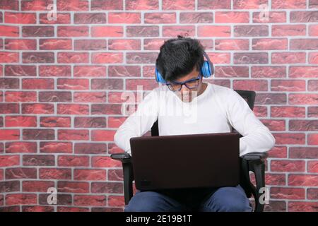 Work from home concept, young man with headphone typing on laptop  Stock Photo