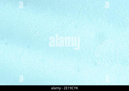 Blue soapy surface closeup. Foamy cleansing skin care product texture from soap, detergent, shampoo, shaving foam. Foam macro background with bubbles Stock Photo