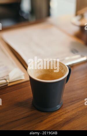 Empty coffee mug with coffee stain on wooden cafe table Stock Photo