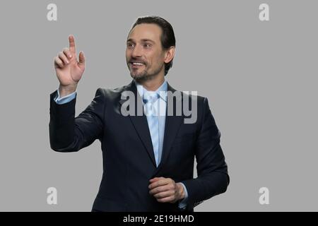 Smiling businessman using invisible interface. Stock Photo