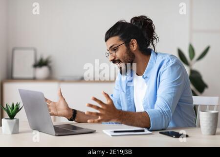 Young Arab Freelancer Guy Making Video Call With Laptop At Home Stock Photo