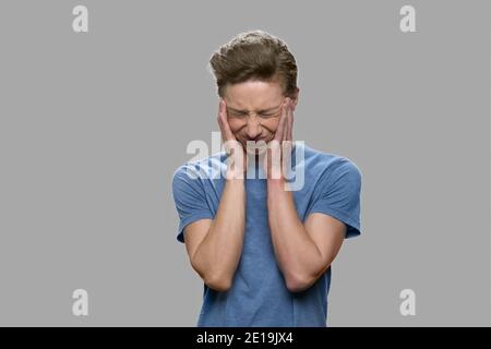 Upset teenage boy suffering from headache. Stock Photo