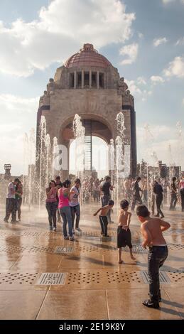 Children and young people play in fountains near the Monument to the Revolution, Mexico City, Mexico Stock Photo