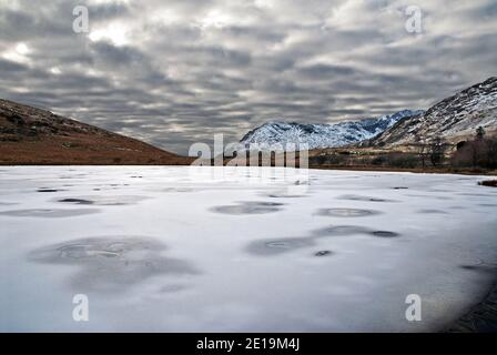 Llyn Pen y Gwryd (Llyn Lockwood) near the Pen-y-Gwryd Hotel in Snowdonia was created in the 1920s as a trout lake. Shown here frozen over. Stock Photo