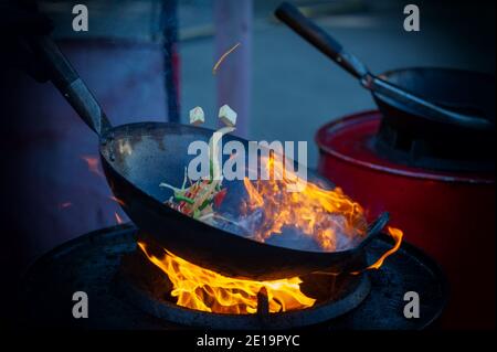 Cooking street food on a hot frying pan. Street food festival Stock Photo