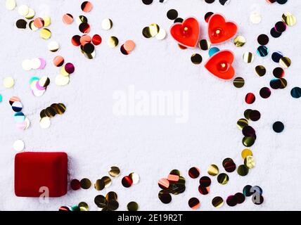 Colorful confetti, heart-shaped candles and ring box. Space for advertisement. St.Valentine's day and proposal concept. Stock Photo