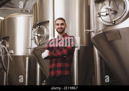 Cheerful successful brewer posing at his microbrewery Stock Photo