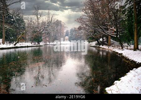 Park of Monza after a snowstorm with the Pond frozen, and the footpath covered with snow. Monza, Lombardy, Italy Stock Photo