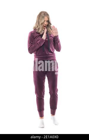 Scared scared young woman looking down at floor seeing something scary defending with hands. Full body length isolated on white background. Stock Photo