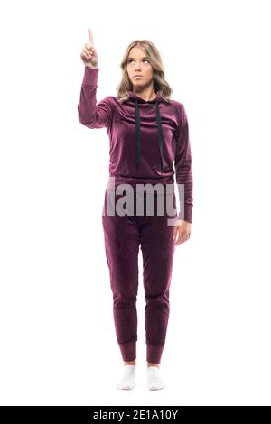 Confident young woman in home comfy clothes using touch screen interface with fingers. Full body length isolated on white background. Stock Photo