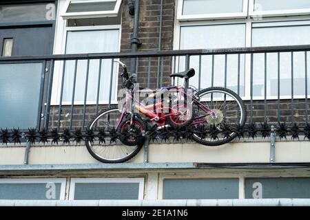 London,England:17 Jul,2012.  Two bikes are secured to a railing at a housing estate in Haggerston in the London Borough of Hackney, East London. Alamy Stock Photo