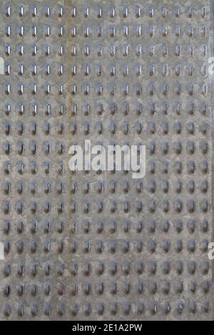 Vertical image of a sheet of perforated metal. Close-up. Stock Photo