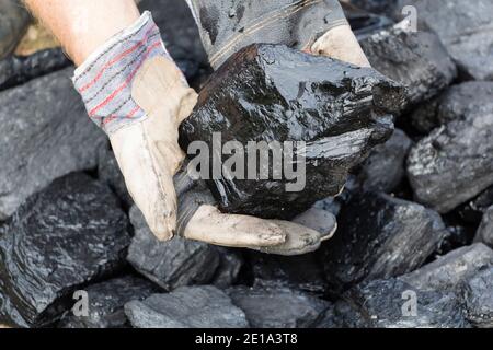 A man holding a piece of coal Stock Photo