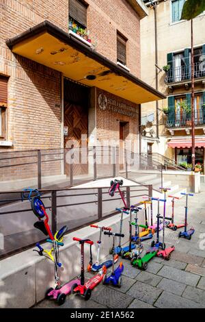 Children’s Micro Scooters Outside A School In The Jewish Quarter Of Venice, Italy. Stock Photo