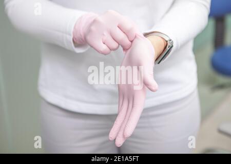 Cropped shot of female doctor putting on rubber gloves before surgery Stock Photo