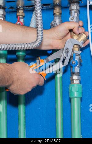 Plumber attaches to pipe gas boiler using adjustable wrench Stock Photo