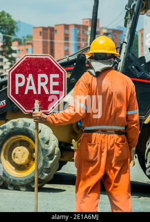 A man is holding a stop sign at the construction place, to warning people transiting near by Stock Photo