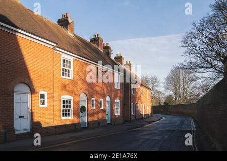 Attractive Georgian style terrace house on the bend in a quiet wall lined road in winter sunshine with shadows of trees. Stock Photo