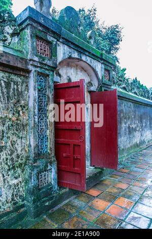 Red wooden Chinese doors Buddhist temple architecture Forbidden Purple City in the Hue Imperial Royal Palace, Vietnam. Stock Photo