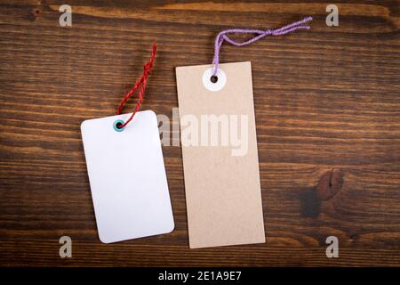 Cardboard and white paper price tags on a wooden texture background. Stock Photo