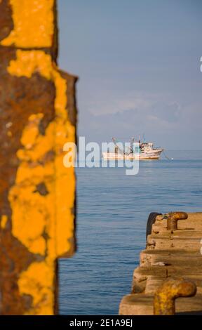 Fishing boats near its docking places, some of them are parked and tied on the dock Stock Photo