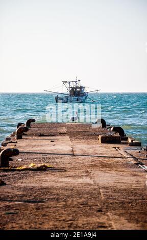 Fishing boats near its docking places, some of them are parked and tied on the dock Stock Photo