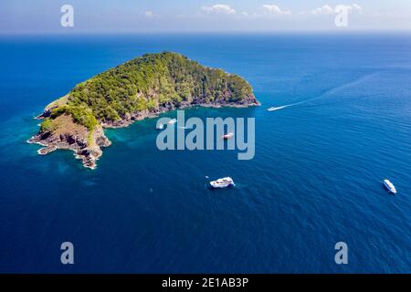 SCUBA diving boats and diver around a rugged, remote tropical island (Koh Bon island, Similan Islands, Thailand).. Stock Photo