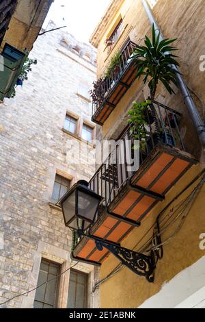 Yellow historic house with street light, flowers and balconies in Barcelona Stock Photo