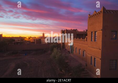 A vibrant sunrise over the village of Merzouga, the gateway to the Erg Chebbi desert dunes in Morocco. Stock Photo