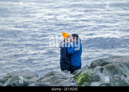 Couple kissing beside ocean Stock Photo